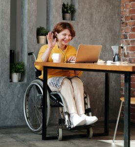 Woman in black wheelchair at laptop PA Pool